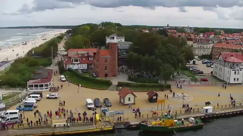 Widok z pylonu na plażę, latarnię morską i kanał portowy.