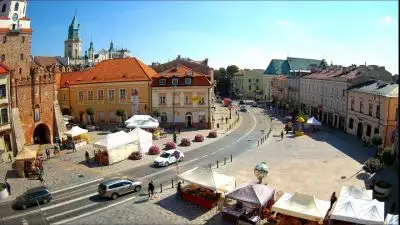 Kamera ustawiona jest na ulicę Królewską, z lewej strony prezentuje Bramę Krakowską a przed nią Plac Łokietka.