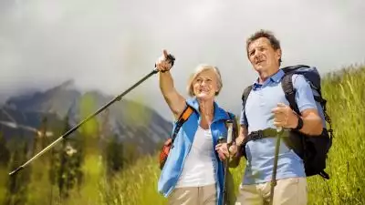 Zdjęcie na parę spacerujących po górach turystów.