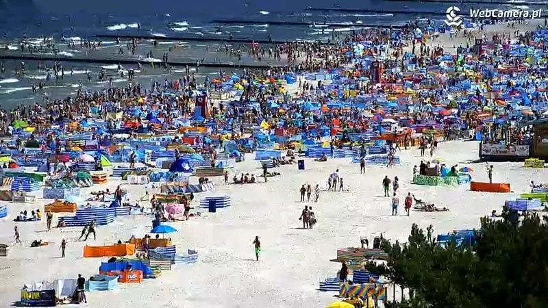 Plaża w Łebie pełna wypoczywających turystów.